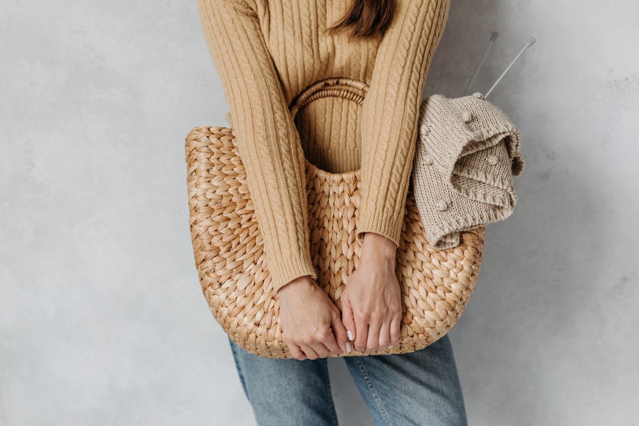 Fashionable autumn look featuring a woven bag and knitted sweater. Ideal for cozy, stylish living.